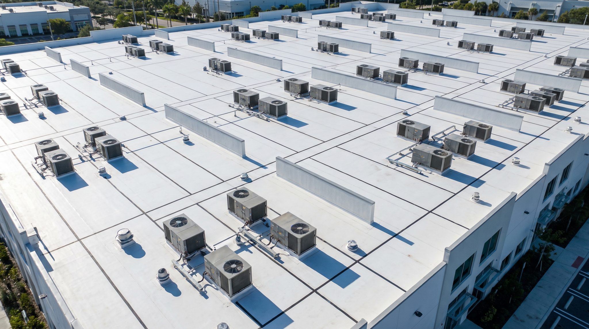 Aerial view of a white TPO flat roof on a commercial building
